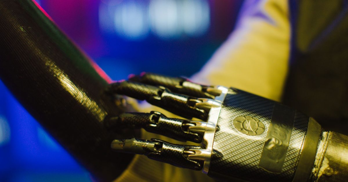 Close-up of a sleek prosthetic hand interacting with a robotic arm in a high-tech environment.