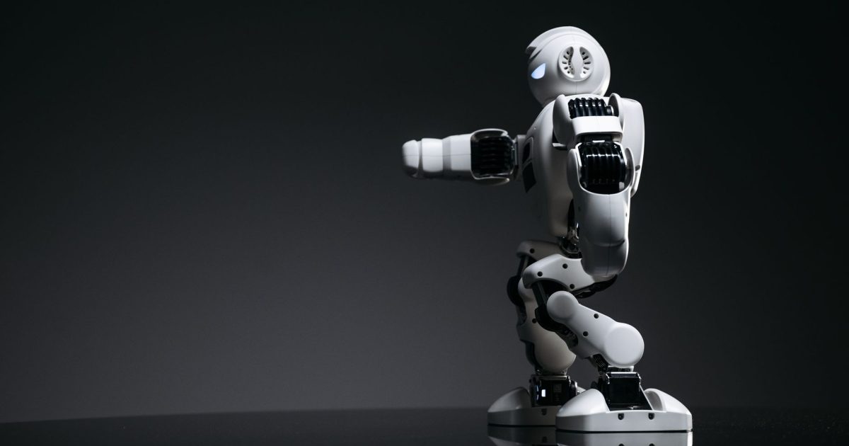 A white robot showcasing modern design on a sleek dark surface.