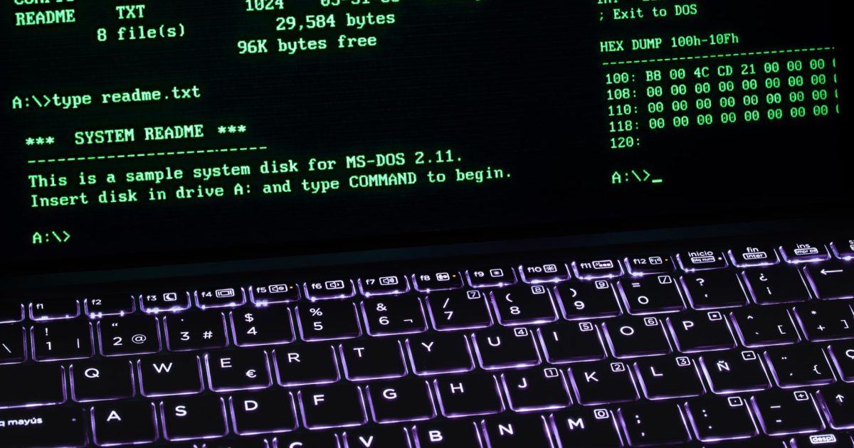A classic MS-DOS terminal screen displayed on a laptop keyboard with vivid illumination.