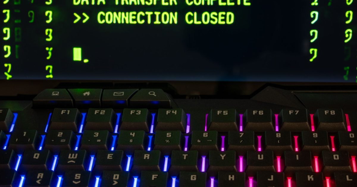 Close-up of a RGB lit keyboard with a screen displaying 'Data Transfer Complete'.