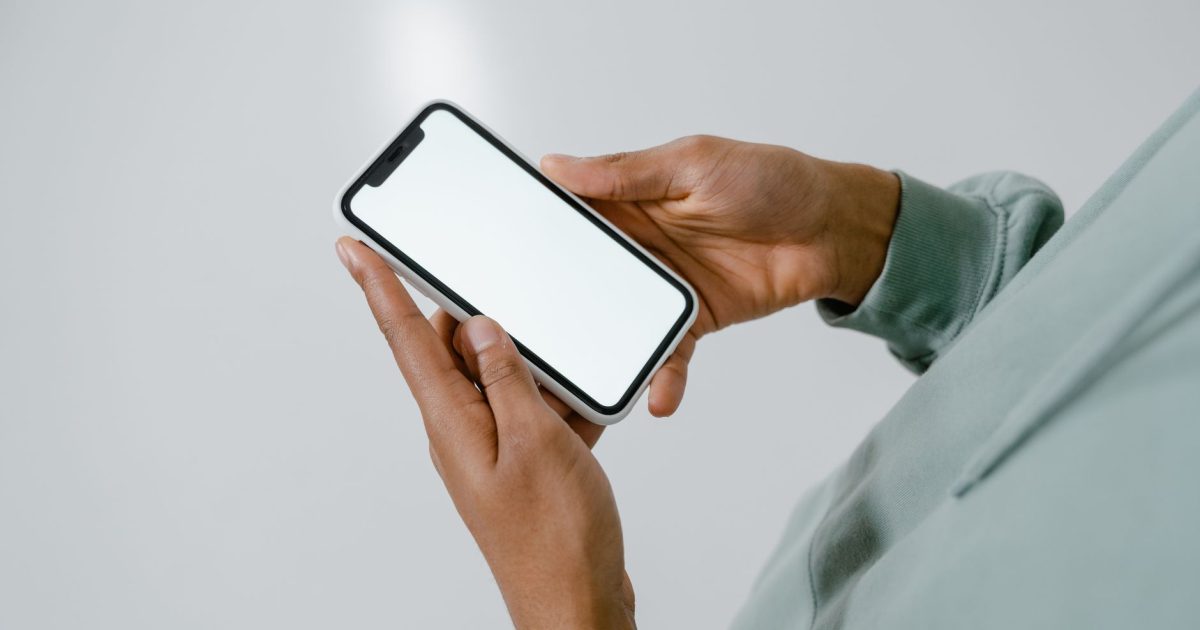 Close-up of hands holding a smartphone with a blank screen, suitable for mockups.