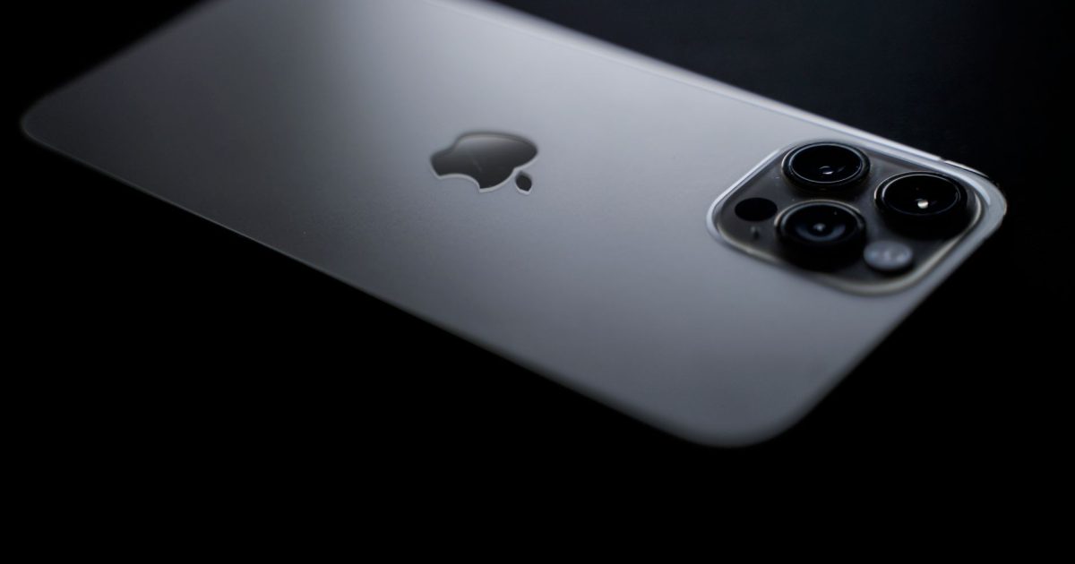 Close-up shot of a sleek smartphone showcasing triple camera lenses on a dark background.