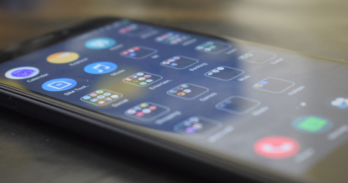 Close-up shot of a smartphone screen showing various app icons, indicating digital technology use.