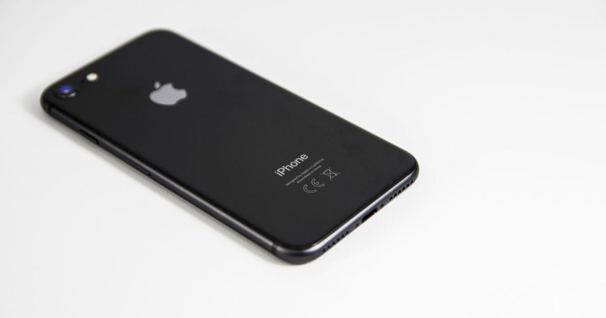 Black smartphone placed on a clean white surface, highlighting modern design and tech elegance.