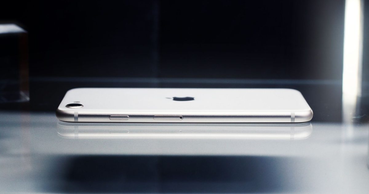 Side view of a sleek smartphone showcasing minimalist design on a reflective surface.