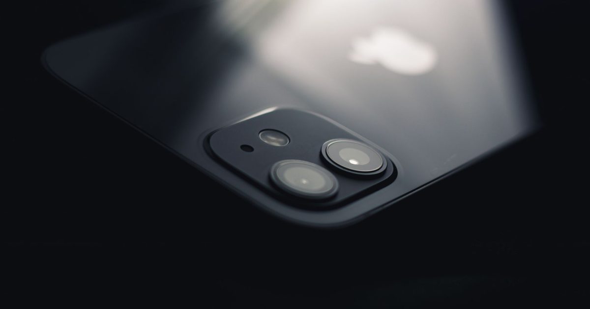 Close-up shot of a smartphone camera lens reflecting light, highlighting modern technology.