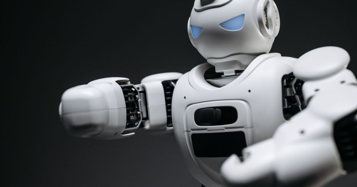 Detailed close-up of a high-tech white robot in a studio setting with a gray background.