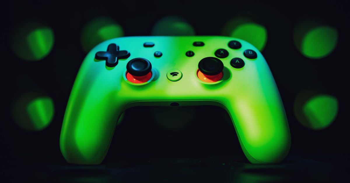 Close-up image of a vibrant green gaming controller illuminated against a dark background.