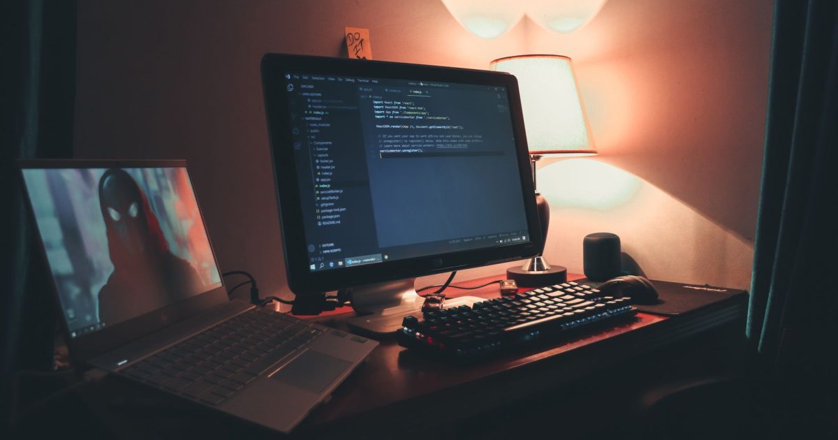 Warmly lit home office with dual screens for coding and programming. Perfect modern workspace for tech enthusiasts.